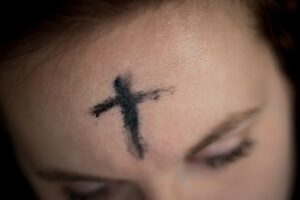 cross streak ashes on woman's forehead
