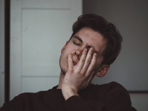 man crying with his hand on his face