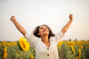 woman stretching her arms while looking at the sky