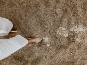 Person walking on sand barefoot