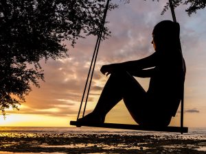 silhouette of a woman on swing