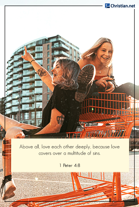 two girls having fun and riding orange grocery carts with a building in the back