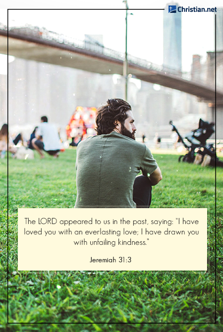 man wearing an olive green shirt sitting on the grass, other people enjoying the outdoors in the background, bible verses about loving yourself