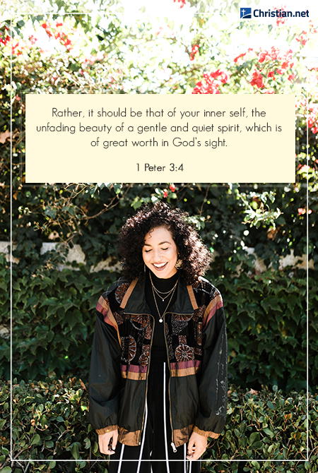 smiling woman with curly hair wearing striped pants, background of flowers, bible verses on inner beauty