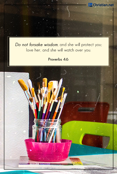 photo of a jar of paintbrushes in a pink plastic bowl, on a school desk with a green chair, prayers for teachers