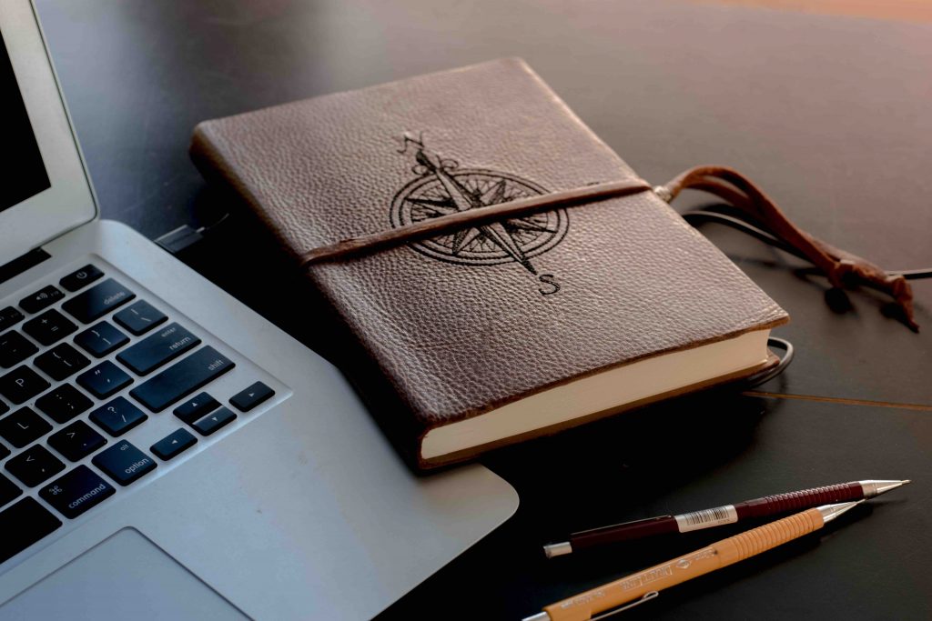 A brown journal with a compass design cover